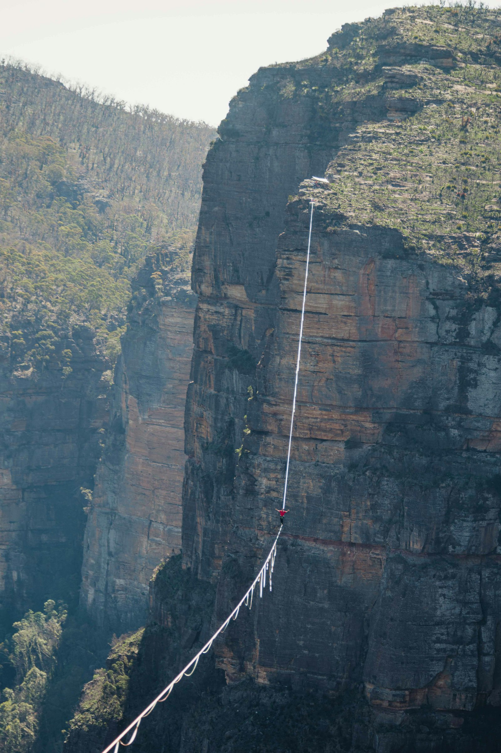 Person secured on a rope while climbing a mountain face